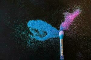 maquillage brosse et brillant rose et bleu paillettes sur une noir Contexte. de fête la magie maquillage concept. modèle pour conception, Haut vue plat allonger copie espace. photo