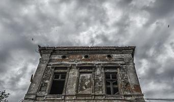 Ancien bâtiment détruit sur un ciel sombre avec des oiseaux