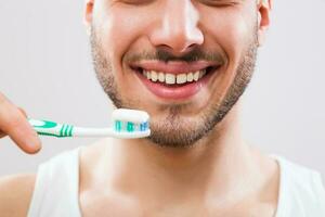 une homme qui prend se soucier de le sien les dents photo