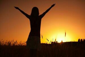 silhouette de une femme à le coucher du soleil photo