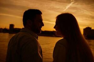 une Jeune couple plus de le le coucher du soleil photo