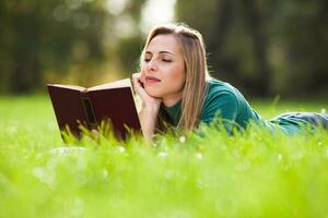 une femme dépenses temps en plein air et en train de lire une livre photo