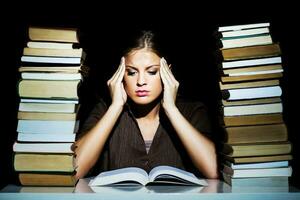 portrait de une stressé femme avec livres photo