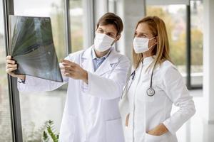 deux médecins masqués regardant une radiographie photo