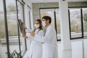 deux médecins masqués regardant une radiographie photo