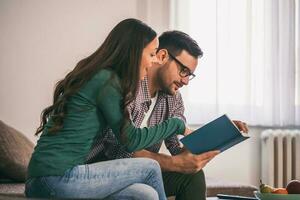 une couple dépenses temps ensemble en train de lire une livre photo