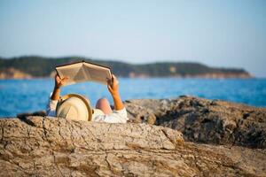 une femme en train de lire à le plage photo