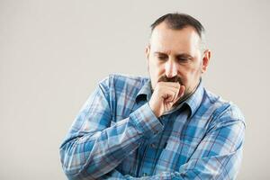 une homme avec une bleu plaid chemise fabrication une visage photo