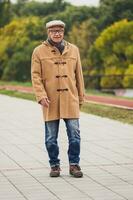 Extérieur portrait de une Sénior homme en marchant dans le parc photo