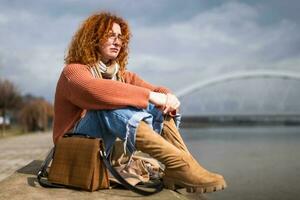 dérangé Jeune femme avec taches de rousseur et frisé gingembre cheveux en plein air photo