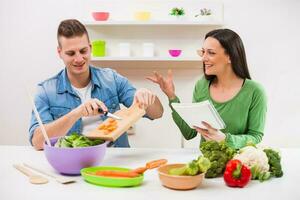 une couple ayant amusement fabrication une salade photo