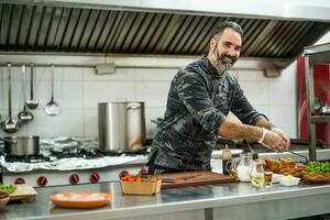 une chef est en train de préparer une repas dans le Restaurants cuisine. photo