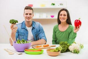 une couple ayant amusement fabrication une salade photo