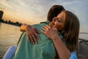 une Jeune couple plus de le le coucher du soleil photo