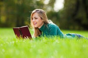 une femme dépenses temps en plein air et en train de lire une livre photo