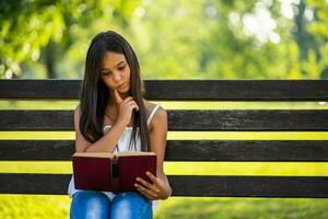 peu fille en train de lire sur le parc photo