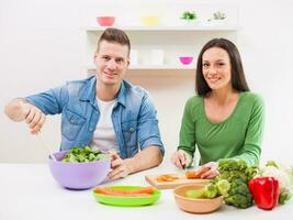 une couple ayant amusement fabrication une salade photo