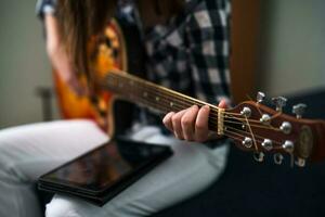 une adolescent fille en jouant guitare photo