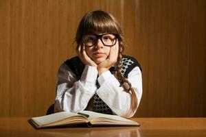 une peu fille en train de lire une livre photo