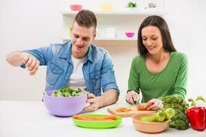 une couple ayant amusement fabrication une salade photo