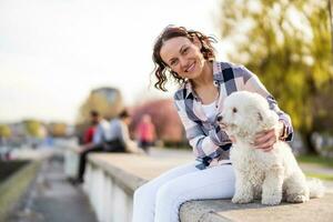 un adulte femme est profiter une ensoleillé journée avec sa chien photo