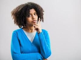 portrait de pensif afro femme avec une bleu cardigan photo