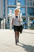 une Sénior femme d'affaires en marchant dans le ville photo