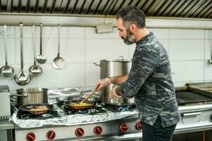 une chef est en train de préparer une repas dans le Restaurants cuisine. photo