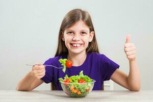 une fille en mangeant une salade photo