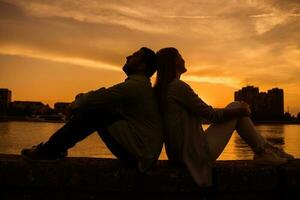 une Jeune couple plus de le le coucher du soleil photo