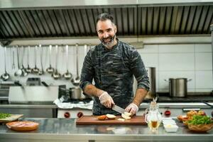 une chef est en train de préparer une repas dans le Restaurants cuisine. photo