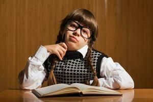 une peu fille en train de lire une livre photo