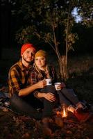 jeune couple, un mec et une fille en chapeaux tricotés lumineux se sont arrêtés dans un camping