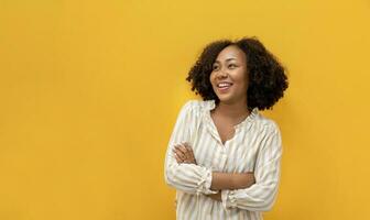 portrait studio coup de africain américain femme souriant dans décontractée tissu avec gros sourire et franchi main isolé sur Jaune Contexte pour femme au foyer et étudiant confiance concept photo