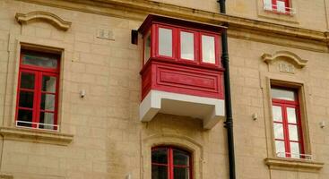 extérieur de typique Maisons sur le méditerranéen île de Malte. typique Résidentiel Maisons dans le villes dans Malte, plusieurs planchers et coloré en bois balcons et magnifique calcaire bâtiments. photo