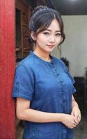 magnifique femme portant traditionnel thaïlandais bleu chemise avec court manches morhom, génératif ai photo