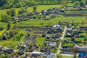 panoramique aérien vue de éco village avec en bois Maisons, gravier route, jardins et vergers photo