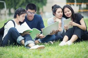 étudiants asiatiques qui étudient sur la pelouse photo