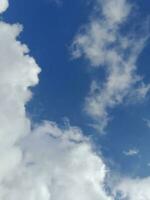 beaux nuages blancs sur fond de ciel bleu profond. de grands nuages doux et moelleux couvrent tout le ciel bleu. photo