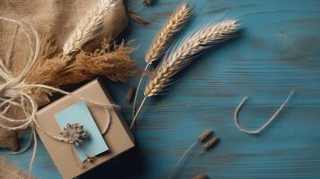 Haut vue de rustique emballé cadeau boîte, toile de jute et séché grain herbe sur bleu ancien en bois tableau, génératif ai. photo