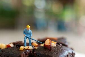 miniature personnes, un employé est fabrication une Chocolat lutin photo