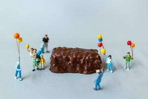 des gamins avec Chocolat bars permanent sur gris Contexte. monde Chocolat journée concept photo