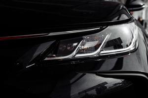 Phare de close-up de voiture noire prestigieuse moderne