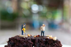 miniature personnes, un employé est fabrication une Chocolat lutin photo