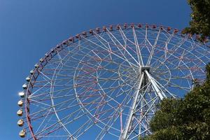 grande roue avec ciel bleu au parc d'attractions photo