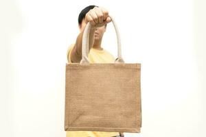 homme en portant jute sac ou sac sac sur blanc Contexte. réutilisable achats sac. Plastique gratuit. éco amical concept. sac sac pour réutilisable achats modes de vie, écologie affaires concept. photo