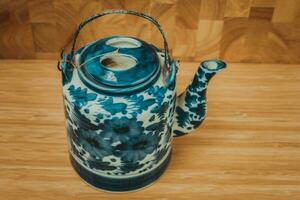 vieux chinois porcelaine théière, avec vert thé sur le en bois. photo