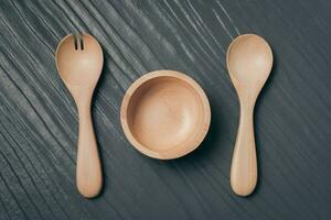 ensemble de fourchette, cuillère et plat bois sur noir en bois table photo