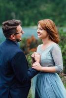 jeune couple en promenade près du lac entouré par les montagnes photo