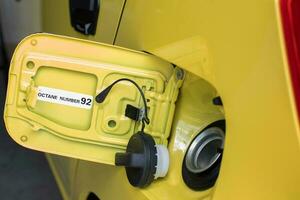 sélectif concentrer sur le Jaune voiture carburant réservoir couverture avec une avertissement en utilisant octane carburant nombre 92. doux concentrer photo